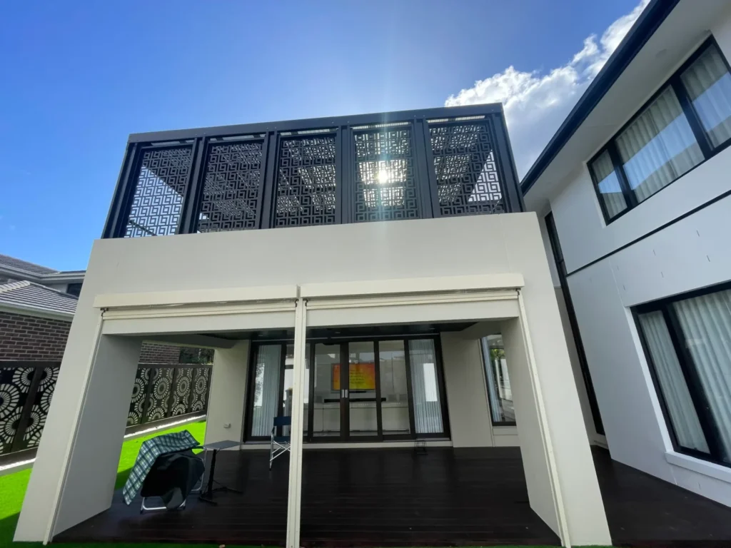 Modern home with clean exterior render and decorative privacy screens.